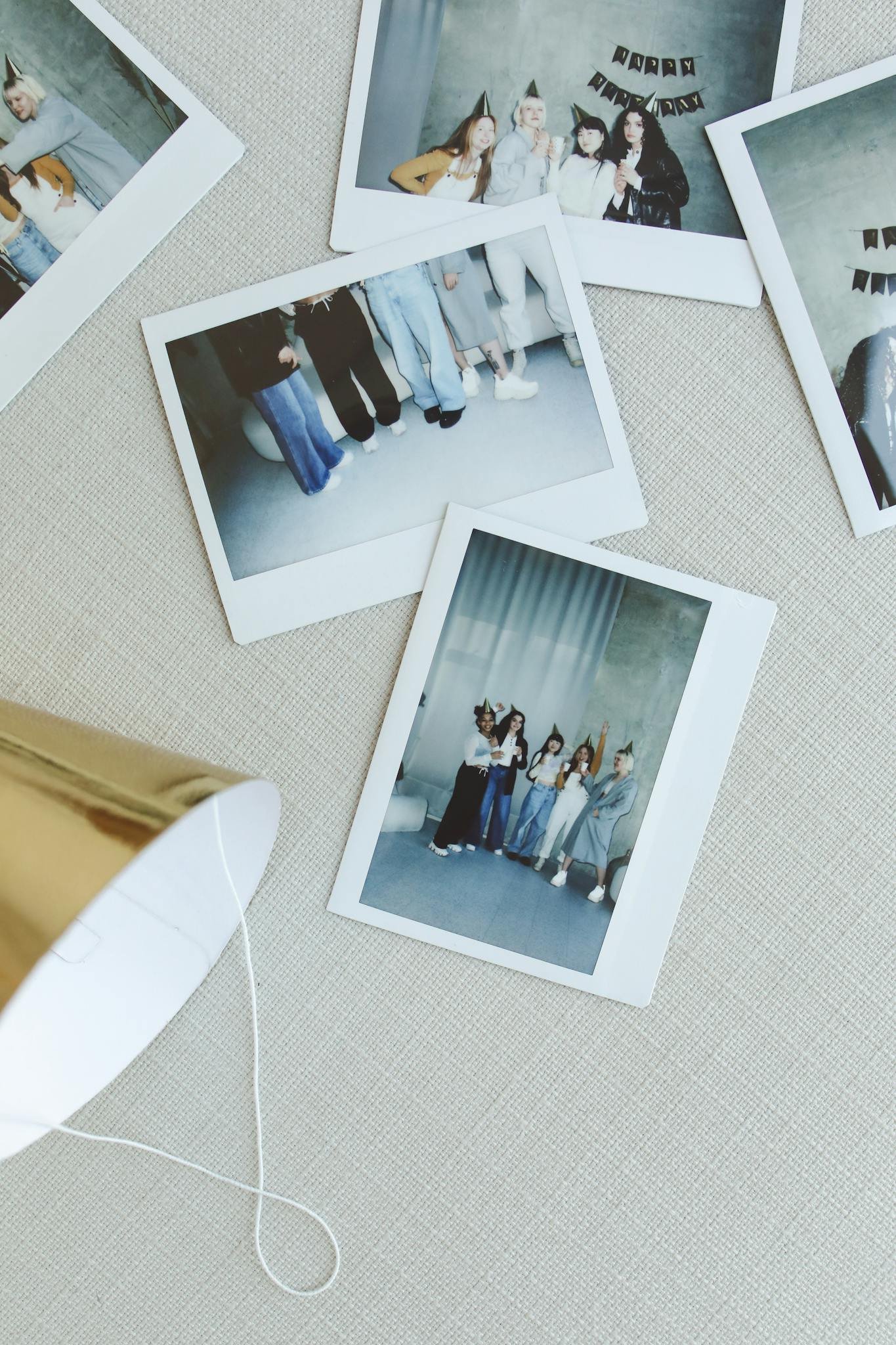 Polaroid photos of friends at a casual indoor celebration with festive hats.